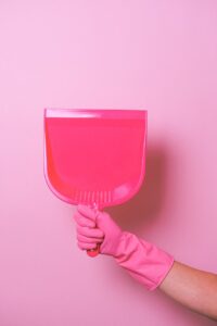 crop faceless person in rubber glove demonstrating dust shovel